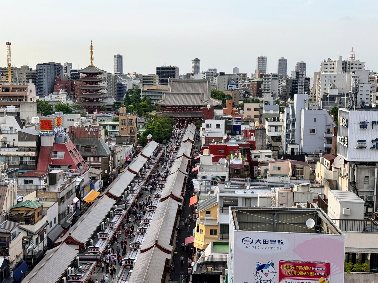 Busy Tokyo street market viewed from above with shops and city buildings