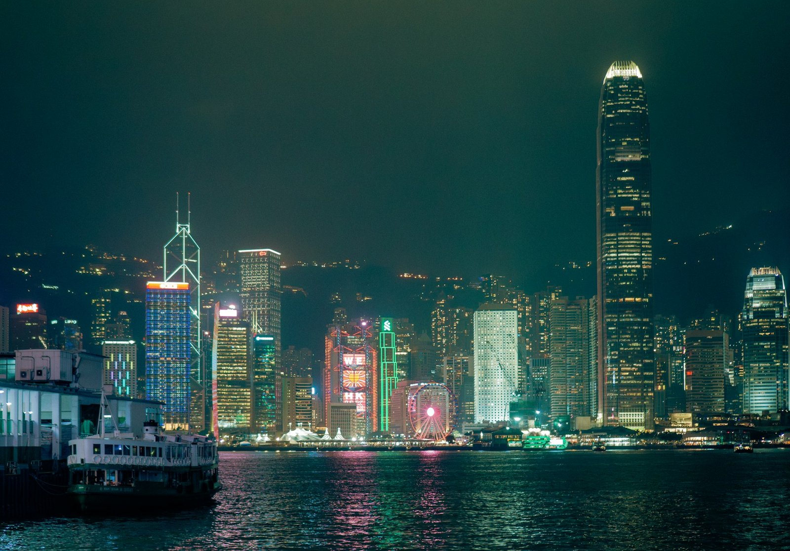 Hong Kong Island skyline illuminated at night across Victoria Harbour